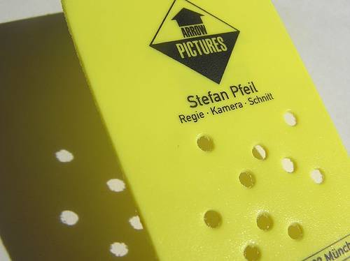 Plastic business card with cut out holes.